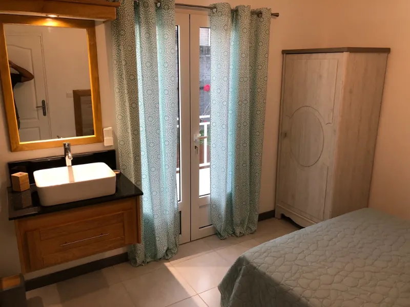 Une chambre Confort, son lavabo et sa porte-fenêtre sur la terrasse